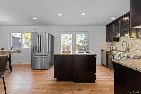 a kitchen with a refrigerator and a stove top oven