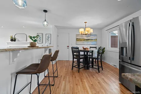 a dining room with furniture a chandelier and wooden floor
