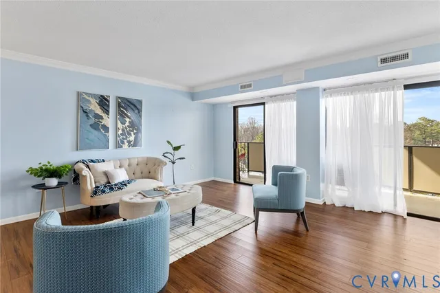 a living room with furniture and floor to ceiling windows