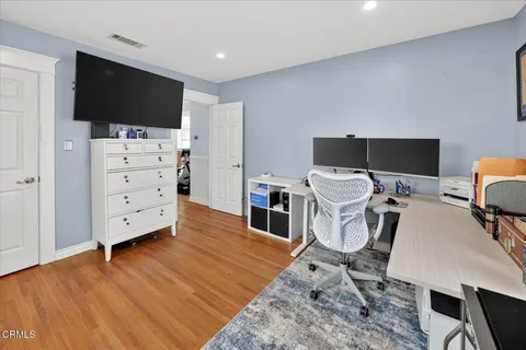 a view of a workspace with furniture and wooden floor