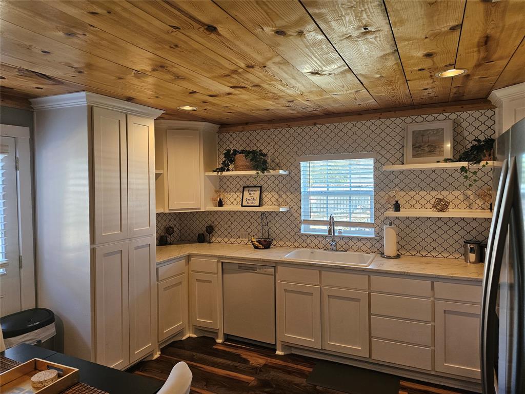 165 Elmwood Road Whitney, TX 76692 - Photo 11 of 28 Kitchen featuring open shelves, dishwasher, freestanding refrigerator, wooden ceiling, and white cabinets