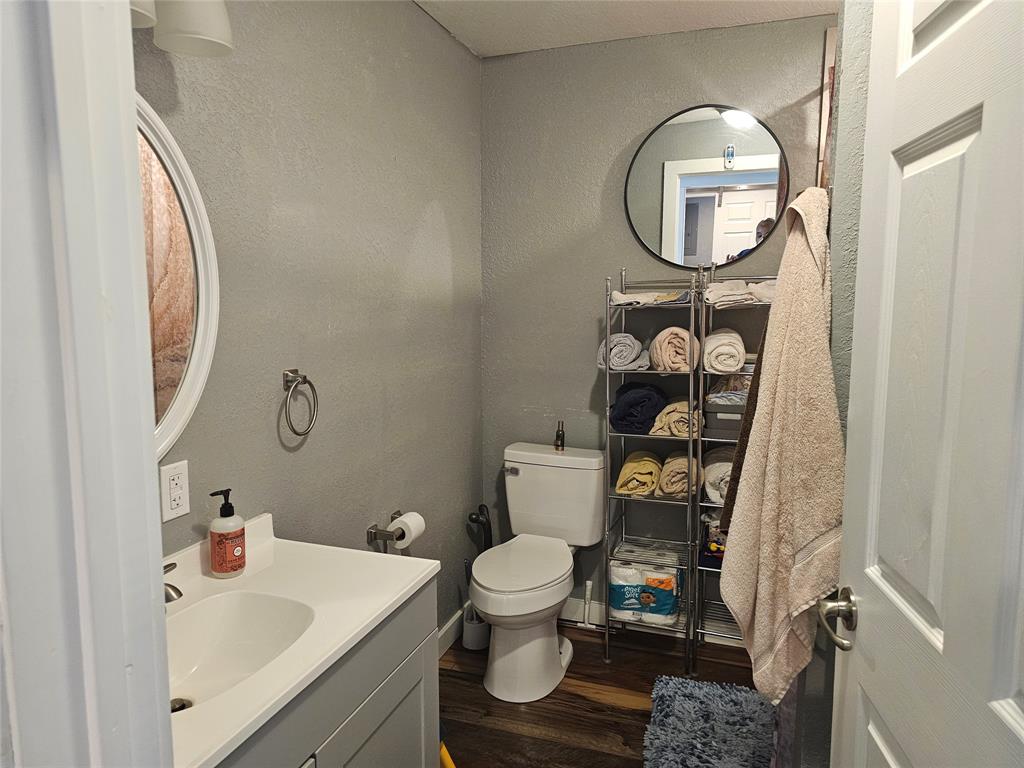 165 Elmwood Road Whitney, TX 76692 - Photo 14 of 28 Bathroom with vanity, dark wood-type flooring, and a textured wall