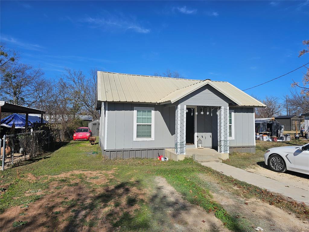165 Elmwood Road Whitney, TX 76692 - Photo 6 of 28 View of front facade with a front lawn, a metal roof, and board and batten siding