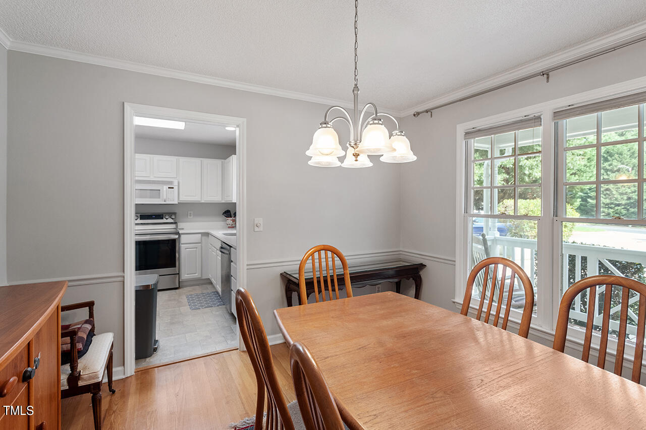 2108 Cedarbluff Court Raleigh, NC 27615 - Photo 15 of 38 a view of a dining room with furniture a chandelier and wooden floor