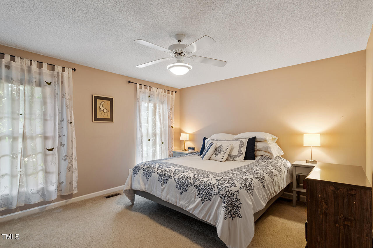 2108 Cedarbluff Court Raleigh, NC 27615 - Photo 18 of 38 a bedroom with a bed and a chandelier