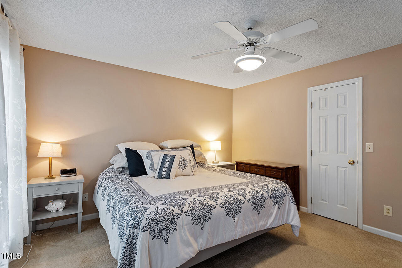 2108 Cedarbluff Court Raleigh, NC 27615 - Photo 19 of 38 a bedroom with a bed and a ceiling fan