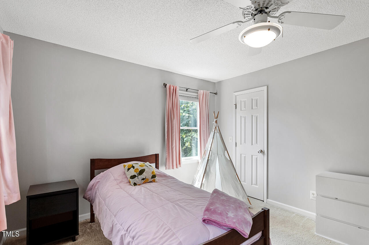2108 Cedarbluff Court Raleigh, NC 27615 - Photo 23 of 38 a bedroom with a bed and chandelier