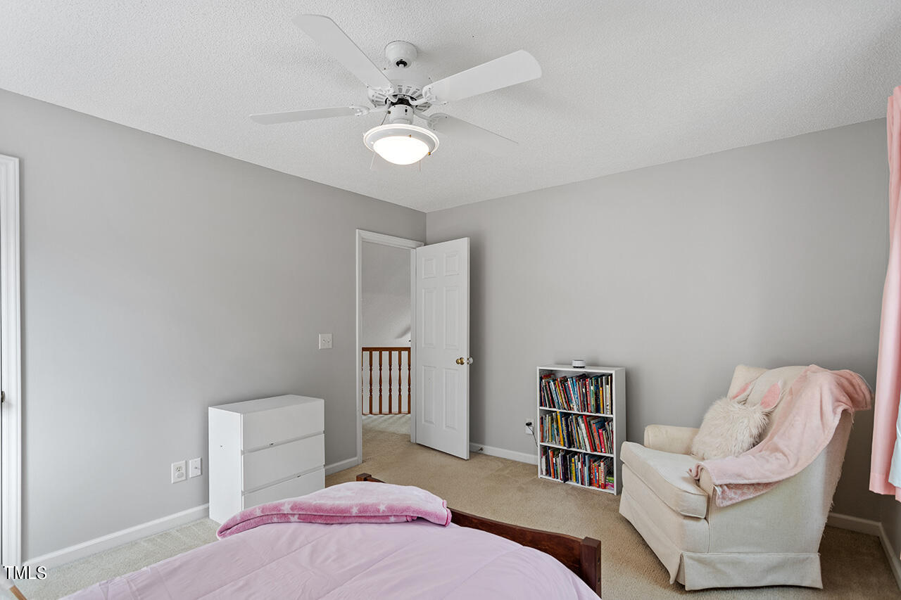 2108 Cedarbluff Court Raleigh, NC 27615 - Photo 24 of 38 a bedroom with a bed and a chandelier