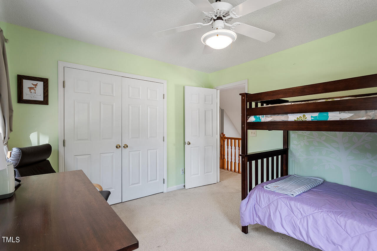 2108 Cedarbluff Court Raleigh, NC 27615 - Photo 27 of 38 a bedroom with a bed and a chandelier