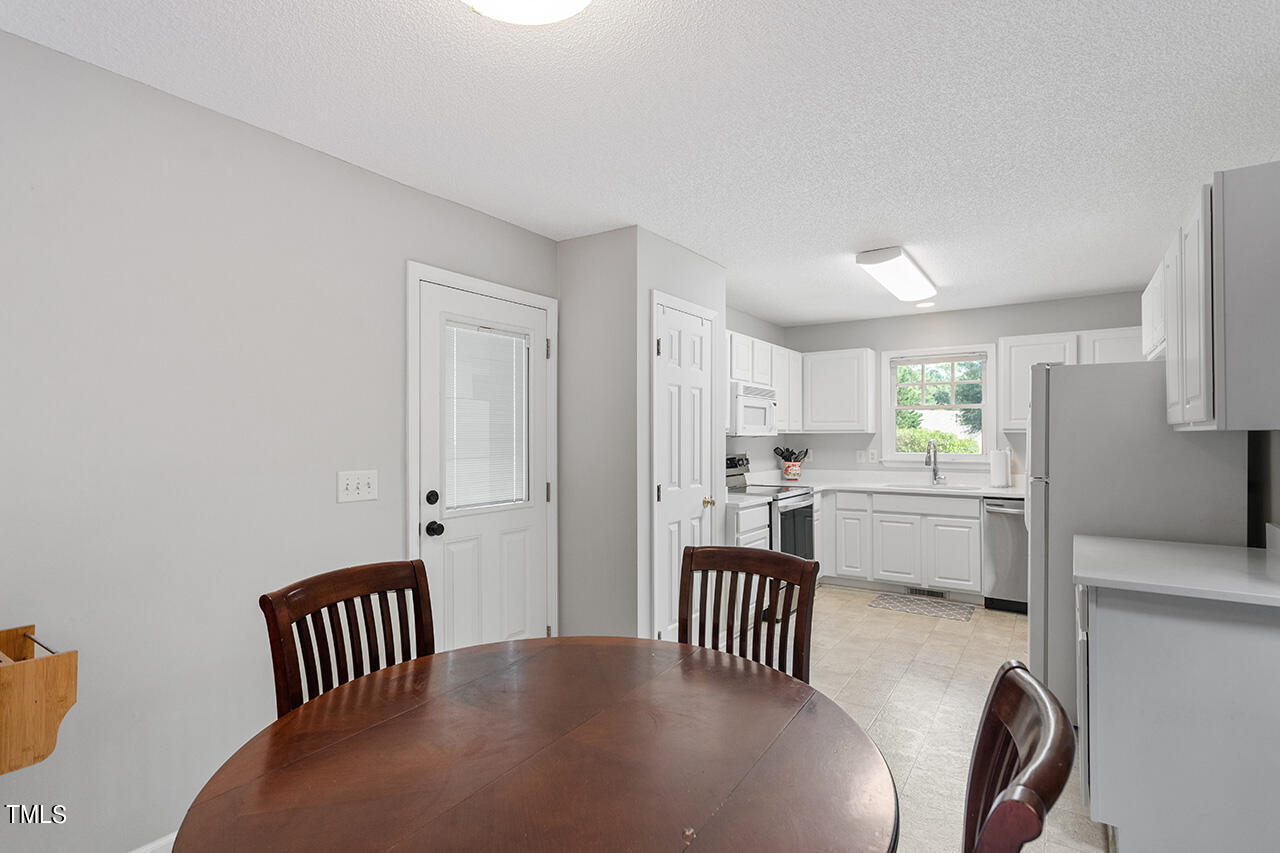 2108 Cedarbluff Court Raleigh, NC 27615 - Photo 9 of 38 a bedroom with a bed next to a window with kitchen view