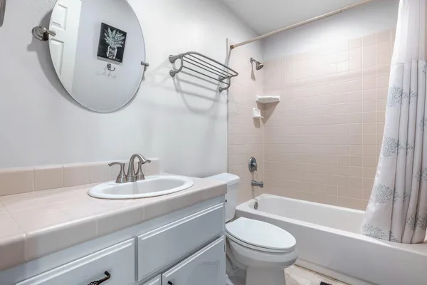 a bathroom with a granite countertop sink and a large mirror