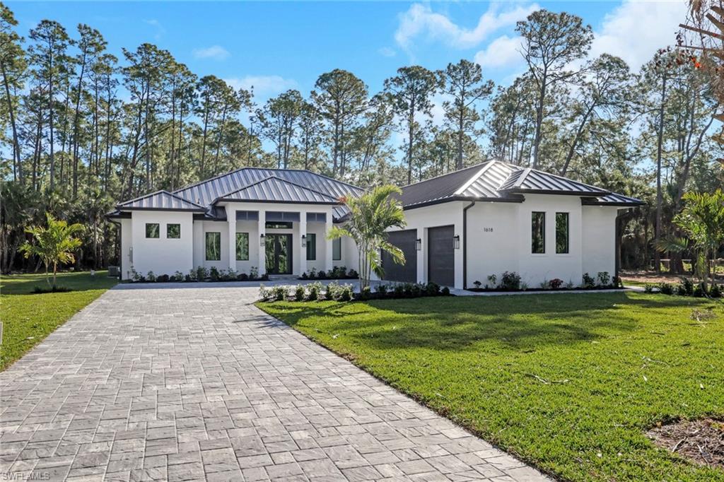 a front view of a house with a garden and trees