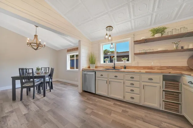 a spacious bathroom with a granite countertop sink a mirror and a chandelier