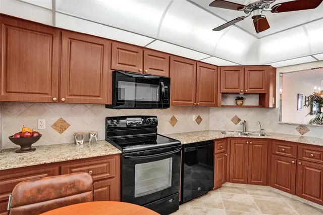 a kitchen with stainless steel appliances granite countertop a sink a refrigerator and cabinets