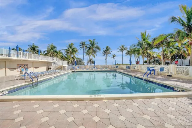 a view of swimming pool with outdoor seating and plants