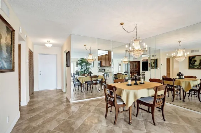 a kitchen with stainless steel appliances granite countertop a stove top oven a sink dishwasher a dining table and chairs with wooden cabinets