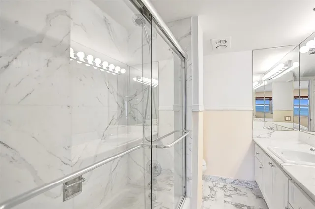 a bathroom with a sink a toilet and shower