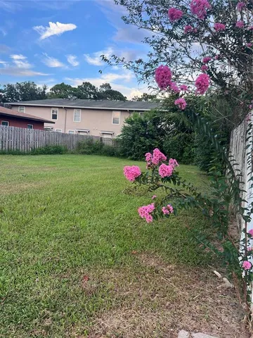 a view of a garden with flowers and a table