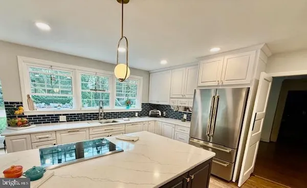 a kitchen with white cabinets and a large window