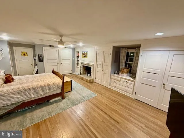 a spacious bedroom with a bed and wooden floor