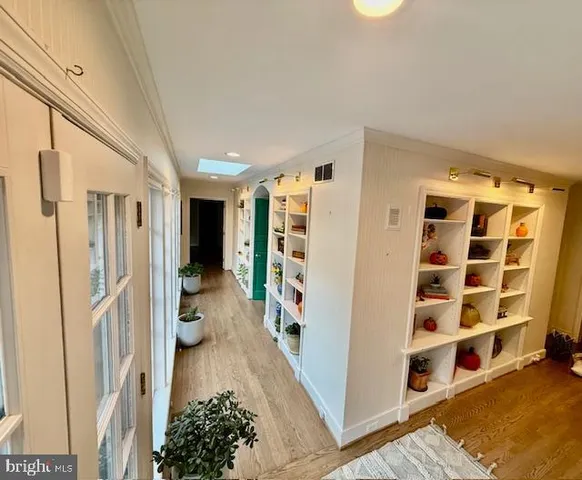 a hallway with white cabinets and black white checkered floor