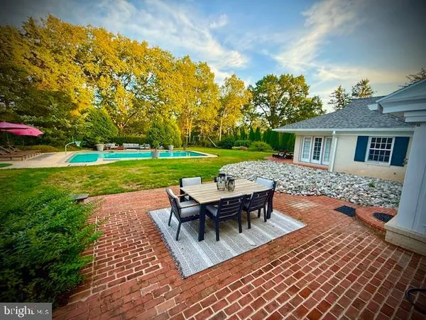 an aerial view of residential house with outdoor space and trees all around