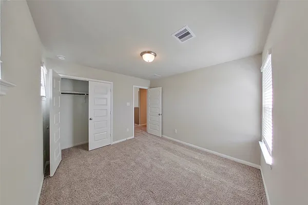 an empty room with closet and windows