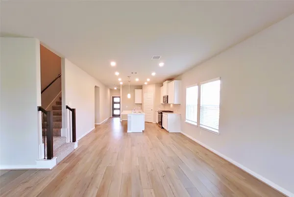 a view of a big room with wooden floor and windows
