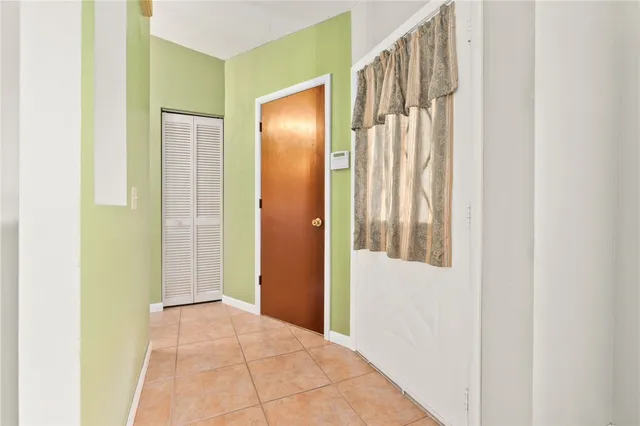 a view of a hallway with wooden floor and a bathroom