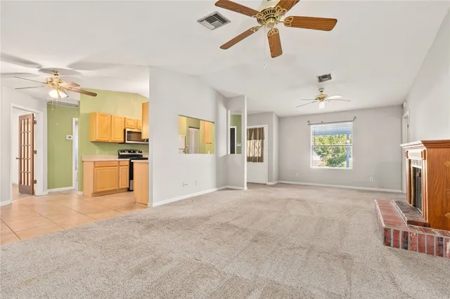 a view of a livingroom with a window and a kitchen