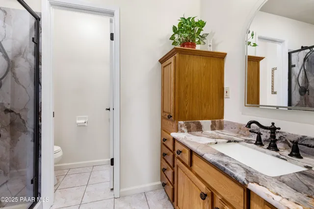 a spacious bedroom with a bed a couch and a flat screen tv