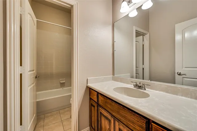 a bathroom with a granite countertop sink a mirror and a shower