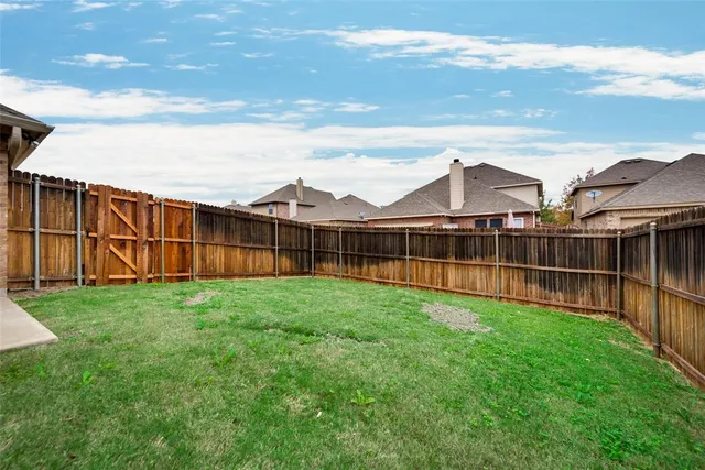 a view of a backyard with wooden fence
