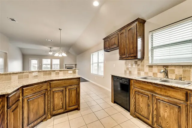 a large kitchen with granite countertop a sink and cabinets