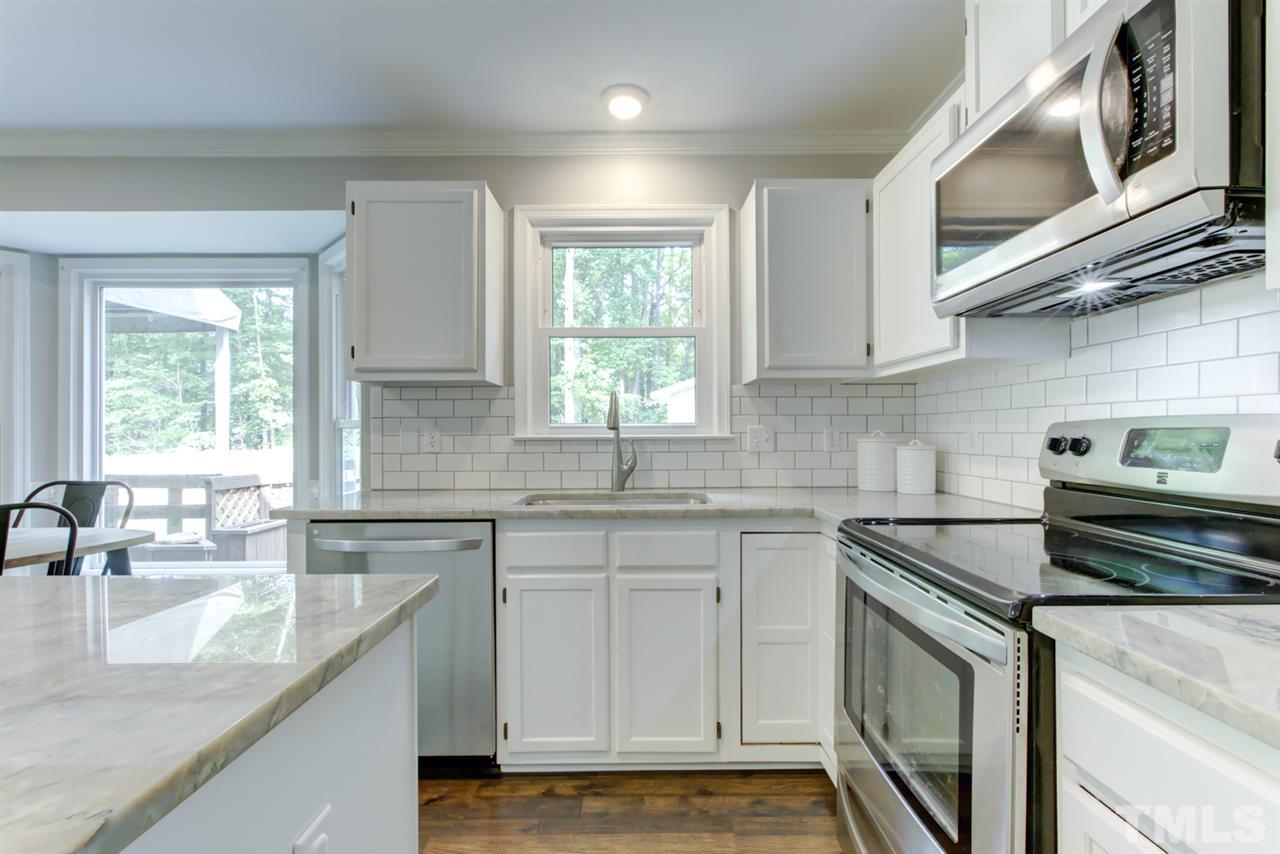 5516 Banwell Place Raleigh, NC 27613 - Photo 8 of 30 White Kitchen includes stainless steel appliances and back splash