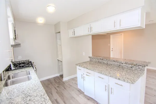 a kitchen with granite countertop a sink and a stove