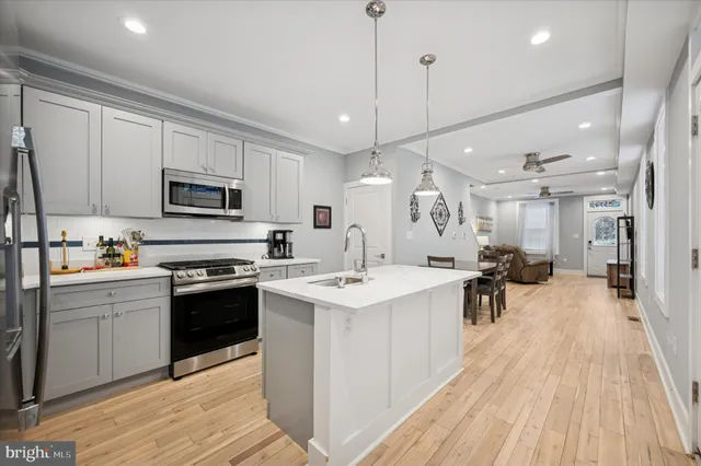 a kitchen with stainless steel appliances kitchen island a sink stove and cabinets