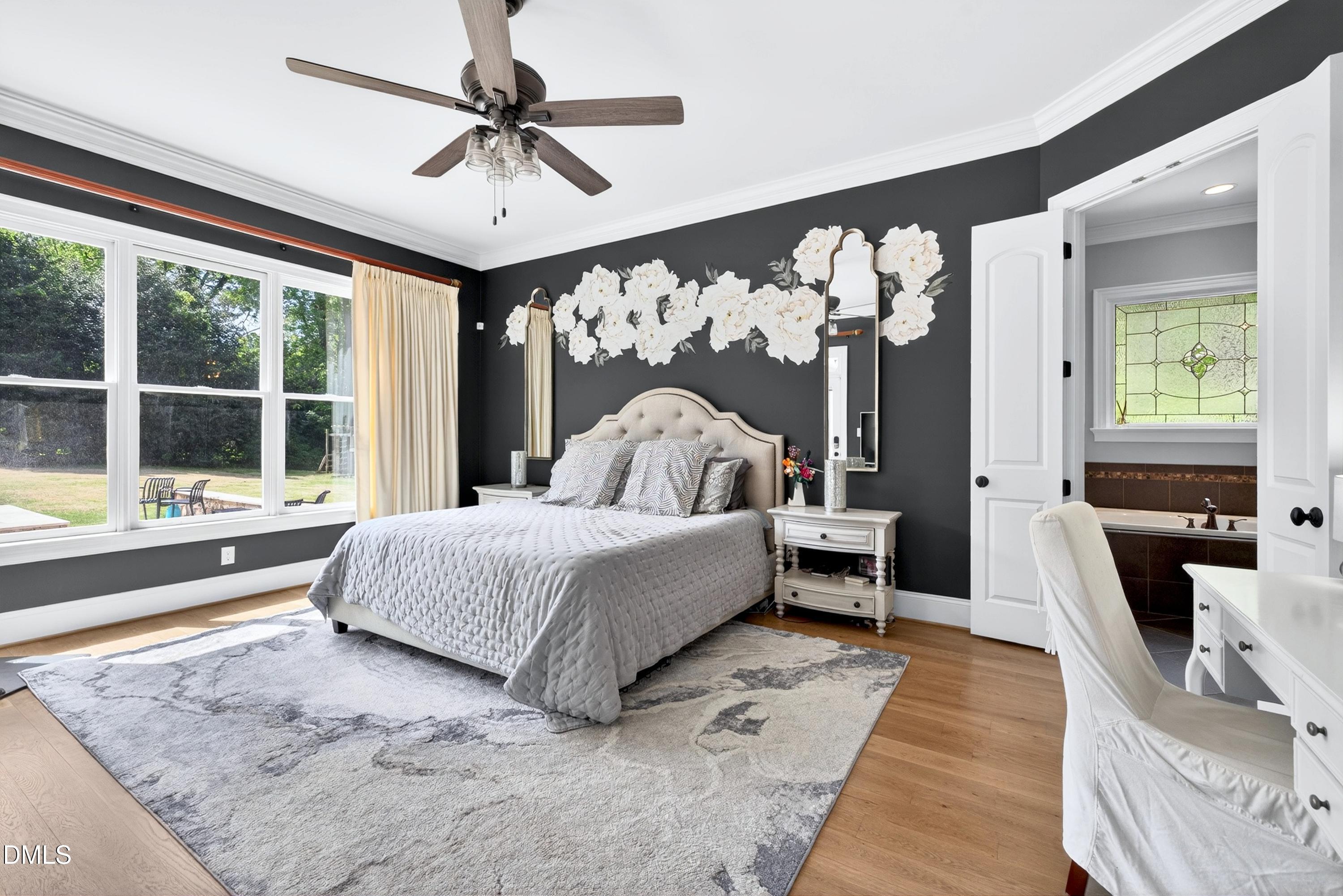 3513 Eilla Bluffs Court Raleigh, NC 27606 - Photo 32 of 86 a spacious bedroom with a large bed and a chandelier