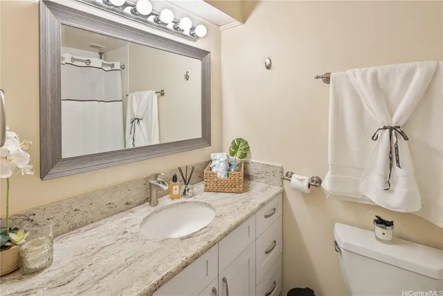 a bathroom with a granite countertop sink vanity mirror and
