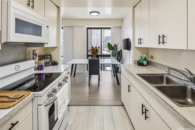 a kitchen with stainless steel appliances a sink a stove top oven a counter space and cabinets