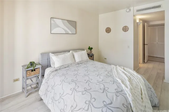 a bedroom with a bed and wooden floor