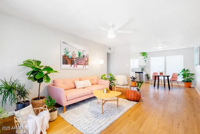 a living room with furniture wooden floor and a table