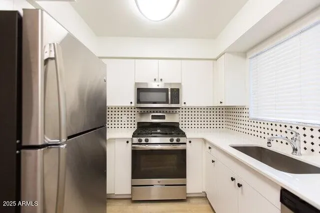 a kitchen with granite countertop a stove and a refrigerator