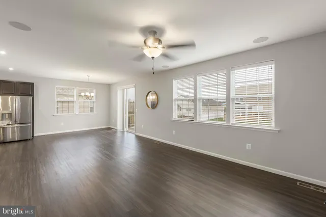 a view of a livingroom with furniture a flat screen tv and wooden floor
