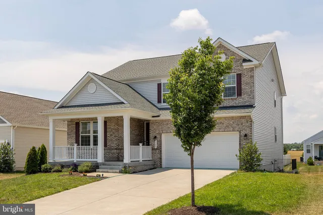 a front view of a house with a yard and potted plants