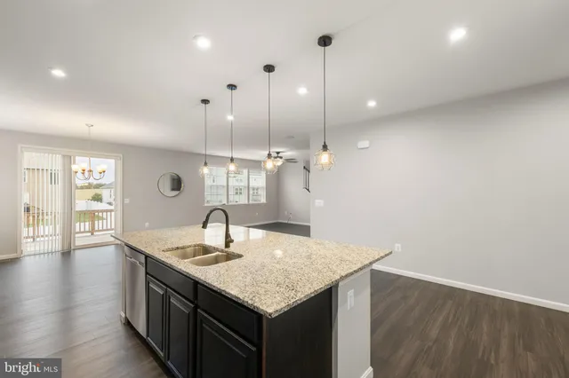 a kitchen with granite countertop a sink and wooden floor