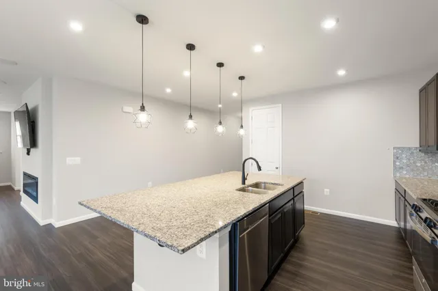 a kitchen with a kitchen island sink stove and wooden floor
