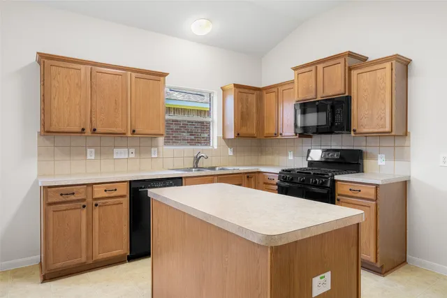 a kitchen with stainless steel appliances a stove a sink a stove top oven a microwave and cabinets