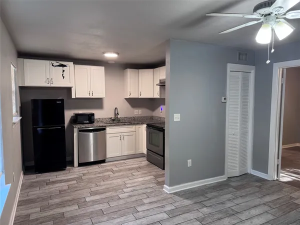 a kitchen with granite countertop a refrigerator stove and sink