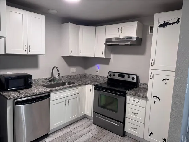 a kitchen with cabinets stainless steel appliances a sink and a counter space